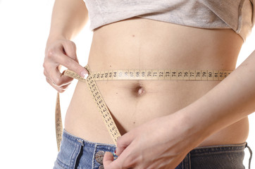 Young woman measuring her waist with tape
