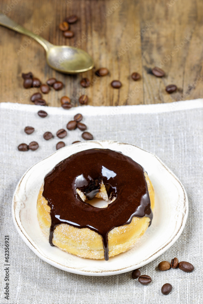 Wall mural Delicious donut with chocolate on wooden table