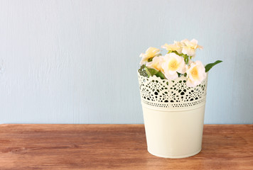 flowers in flowerpot on wooden shelf  