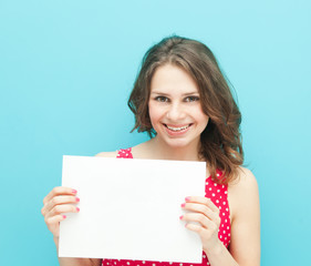Fototapeta premium beautiful girl with a white sheet of paper on a blue background