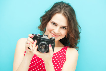 beautiful girl with vintage photo camera on a blue background in