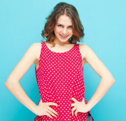 beautiful girl in a red blouse with polka dots on a blue backgro