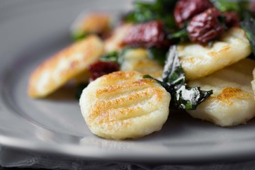 Fried potato gnocchi with sauce of dried tomatoes, spinach