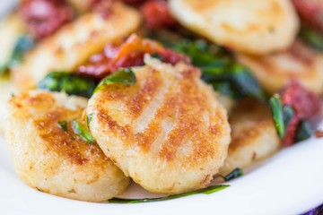 Fried potato gnocchi with sauce of dried tomatoes, spinach