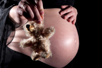 Babybauch mit Teddybär Nahaufnahme