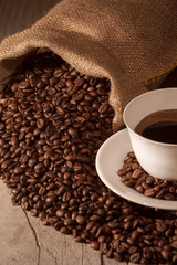Coffee cup with burlap sack of roasted beans