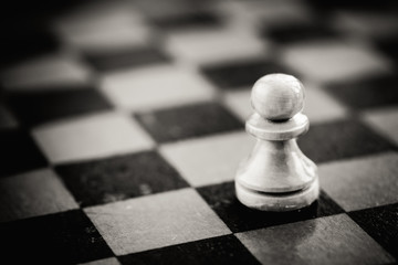 White chess pawn standing on chessboard