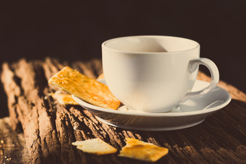 coffee cup and bread on wood