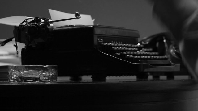 Man typing on a vintage 40's style manual typewriter