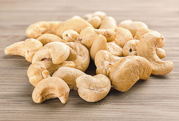 A handful of row cashew nuts on wood background