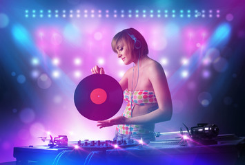 Obraz na płótnie Canvas Disc jockey mixing music on turntables on stage with lights and