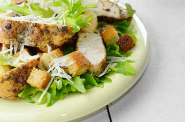 Caesar chicken salad on white table