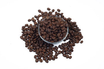 Scattered coffee beans around and within glass jug