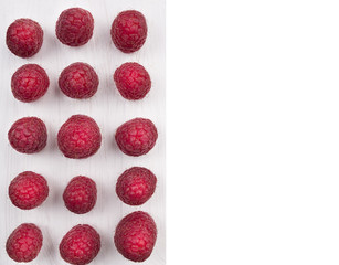 Raspberries laid out in row on white wooden board,isolated