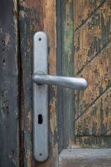 Close-up shot of a weathered keyhole on a wooden door