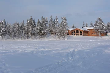 Foto op Aluminium Lodge aan bevroren meer Lapland © fotoroodpad