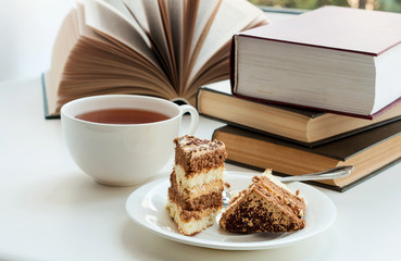 Cup of tea, cake and some books to read lying on the table