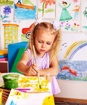 Child painting at easel.
