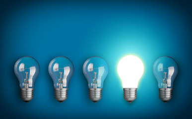 Idea concept with row of light bulbs and glowing bulb