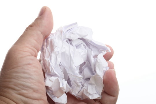 male hand holding crumpled paper over a white