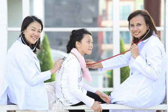 Two women dotor checking lovely girl