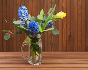 Bouquet from tulips and hyacinths on wooden background.