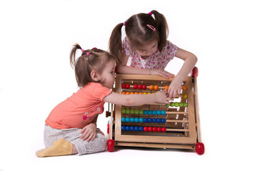 two girls playing with colored bills sitting