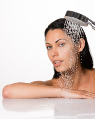 beautiful brunette woman holds shower in hands