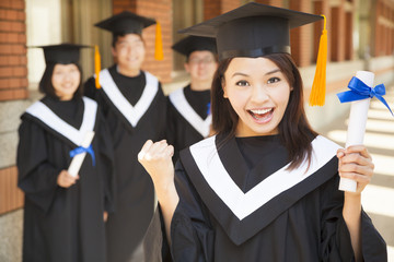 happy college graduate holding diploma  and make a fist