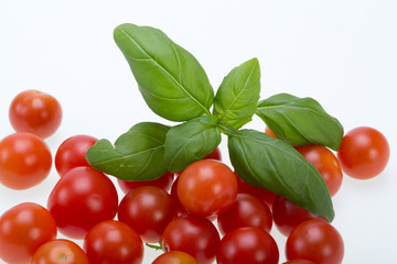 fresh cherry tomatoes with basil, on white background
