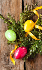 Easter decoration - colorful eggs with buxus on vintage wood