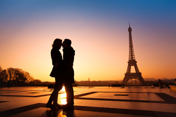 Naklejka premium kochająca para całuje na tle wieży Eiffla, Paryż, Francja