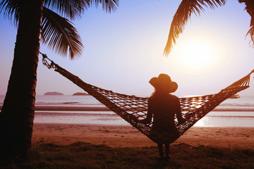 relaxing in hammock at sunset on the paradise beach