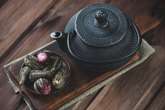 Compressed tea and cast-iron asian teapot, wooden background