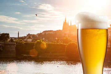 Glass of beer against view of the St. Vitus Cathedral in Prague