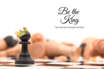 A pawn winner standing crowned as king with copy-space