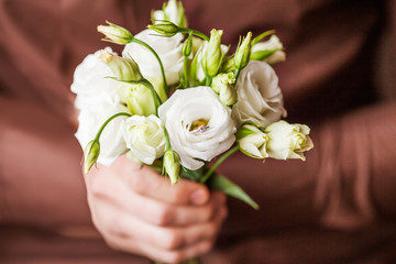  Man holding ring and a bouquet of flowers