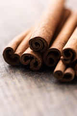 Cinnamon sticks on rustic wooden background closeup
