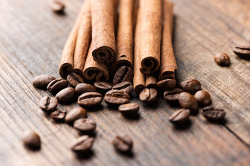 Coffee and cinnamon sticks on wooden background macro
