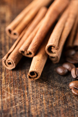 Coffee and cinnamon sticks on grunge wooden background