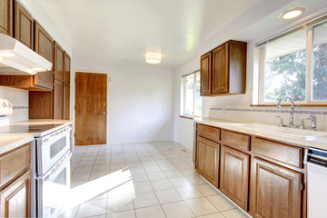 White kitchen room with brown storage combination and white appl