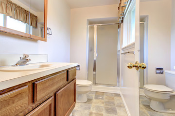 LIght tones bathroom with a glass door shower