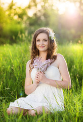 Naklejka na ściany i meble Beautiful spring girl with flowers on the meadow