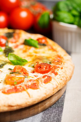 italian pizza on tablecloth with tomatoes half