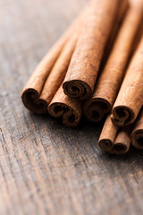 Cinnamon sticks on rustic wooden background close up