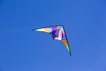Bright colors in kite flying against a blue sky