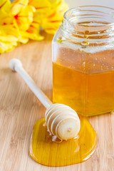 honey dipper on a background of a jar with honey