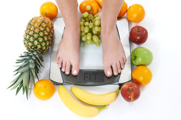 Frau auf Waage mit Obst