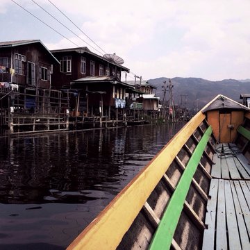 boat floating through a village on Inle Lake in Myanmar