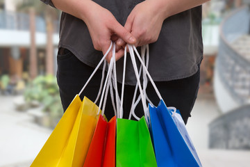 Eine Frau hält bunte Einkaufstaschen in einer Shopping Mall in